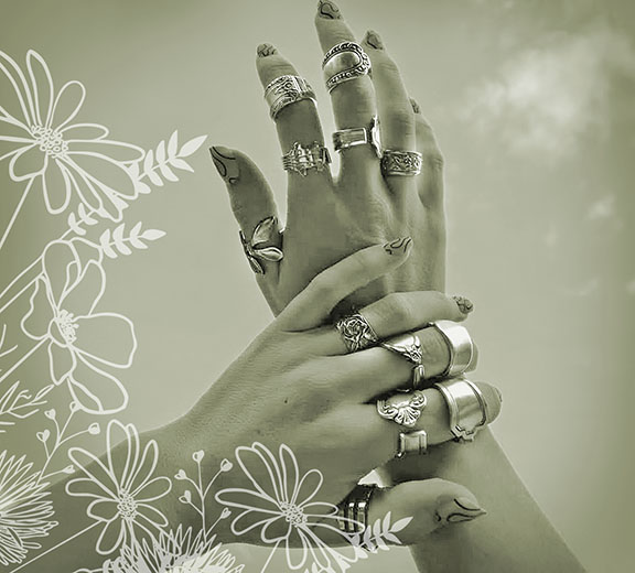 Hands wearing upcycled silverware rings, framed by botanical line art